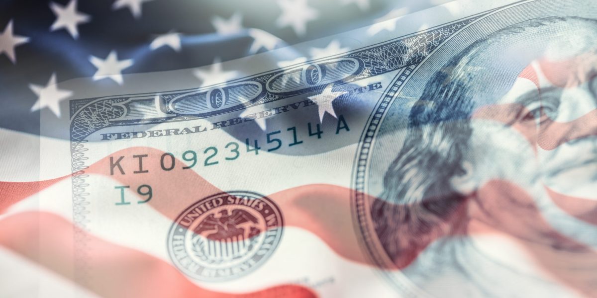 USA flag and American dollars. American flag blowing in the  wind and 100 dollars banknotes in the background.