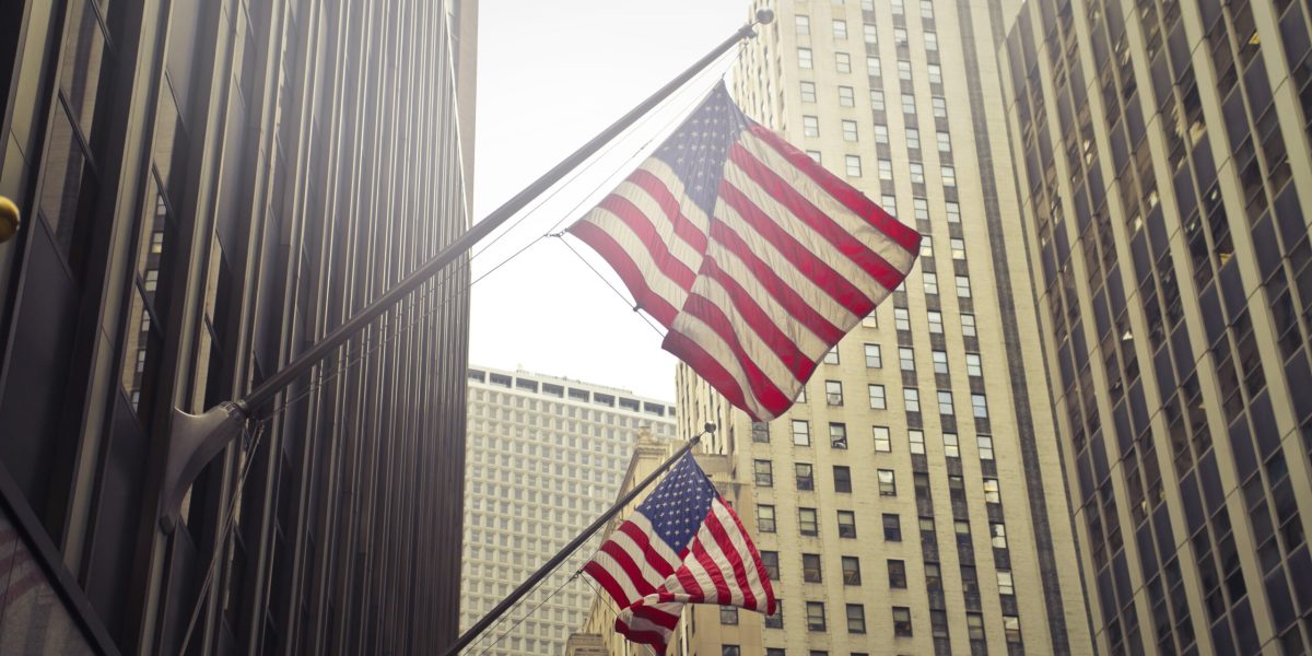 A shot of two American or US flags on a high rise building